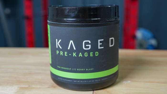 Black tub with white and green writing that reads "KAGED PRE-KAGED" on a table